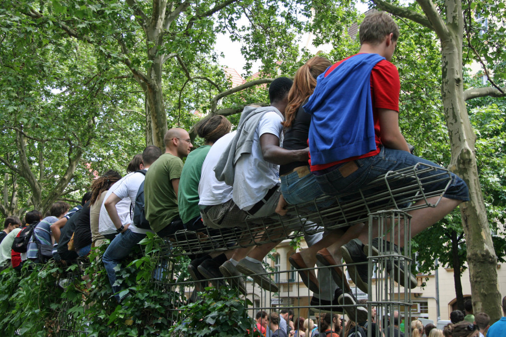 Carnival goers climb a trellis for a better view of the parade at Karneval der Kulturen (Carnival of Cultures) in Berlin