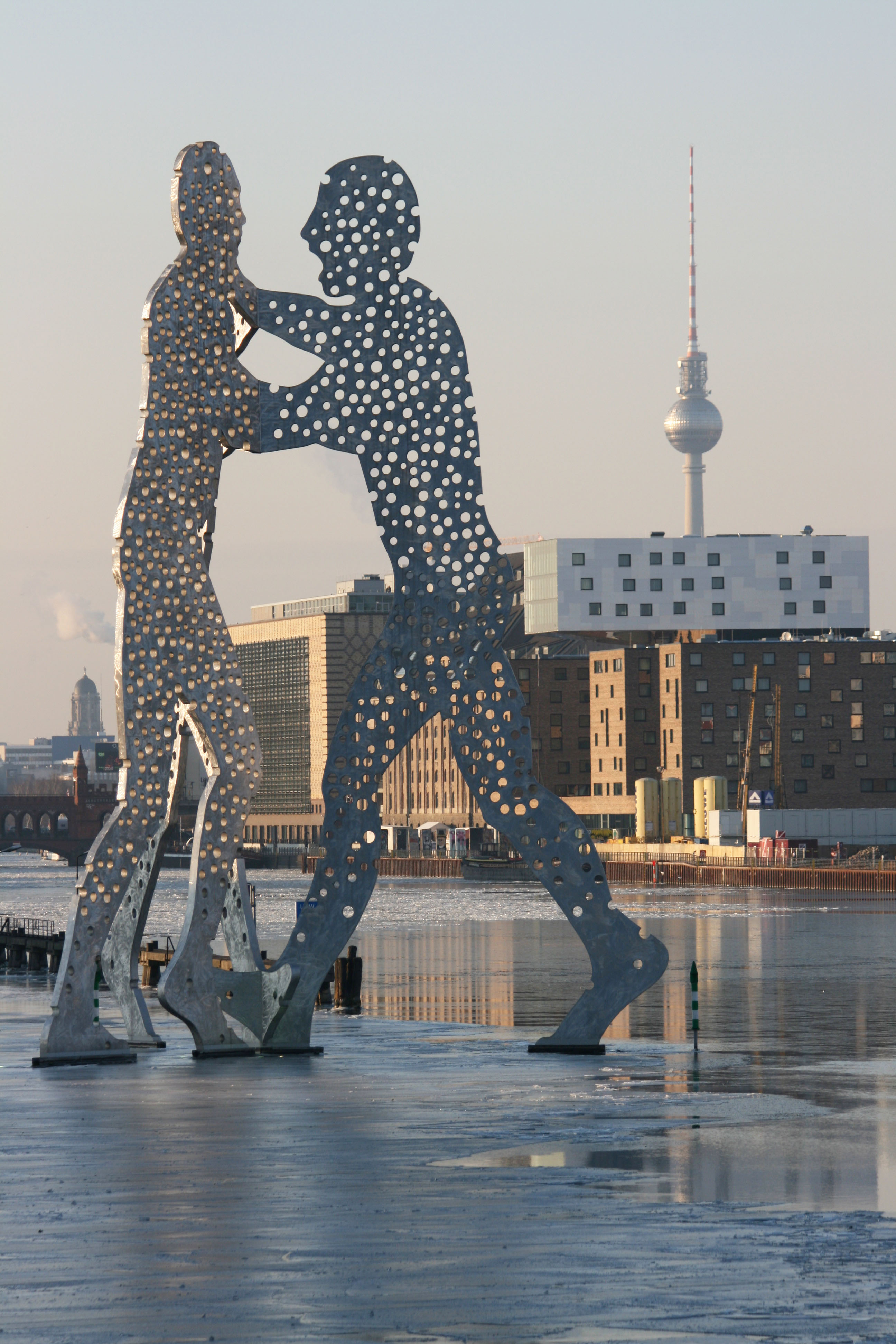 The Molecule Man sculpture by Jonathan Borofsky on a partially frozen Spree and The Fernsehturm in a Berlin Winter