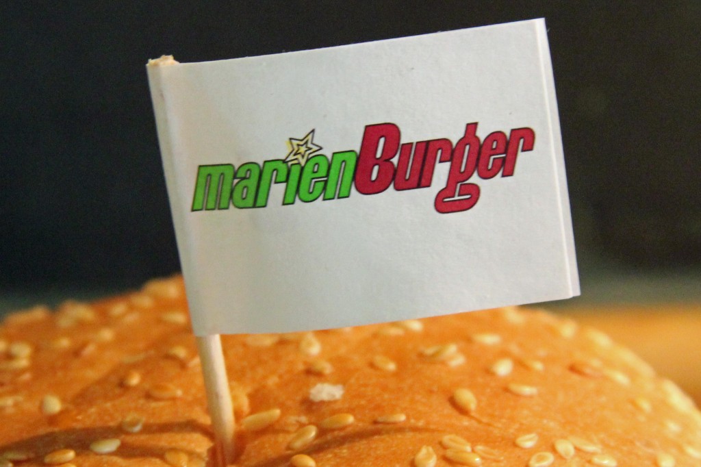The Marienburger logo on a flag stuck in the burger bun in Berlin