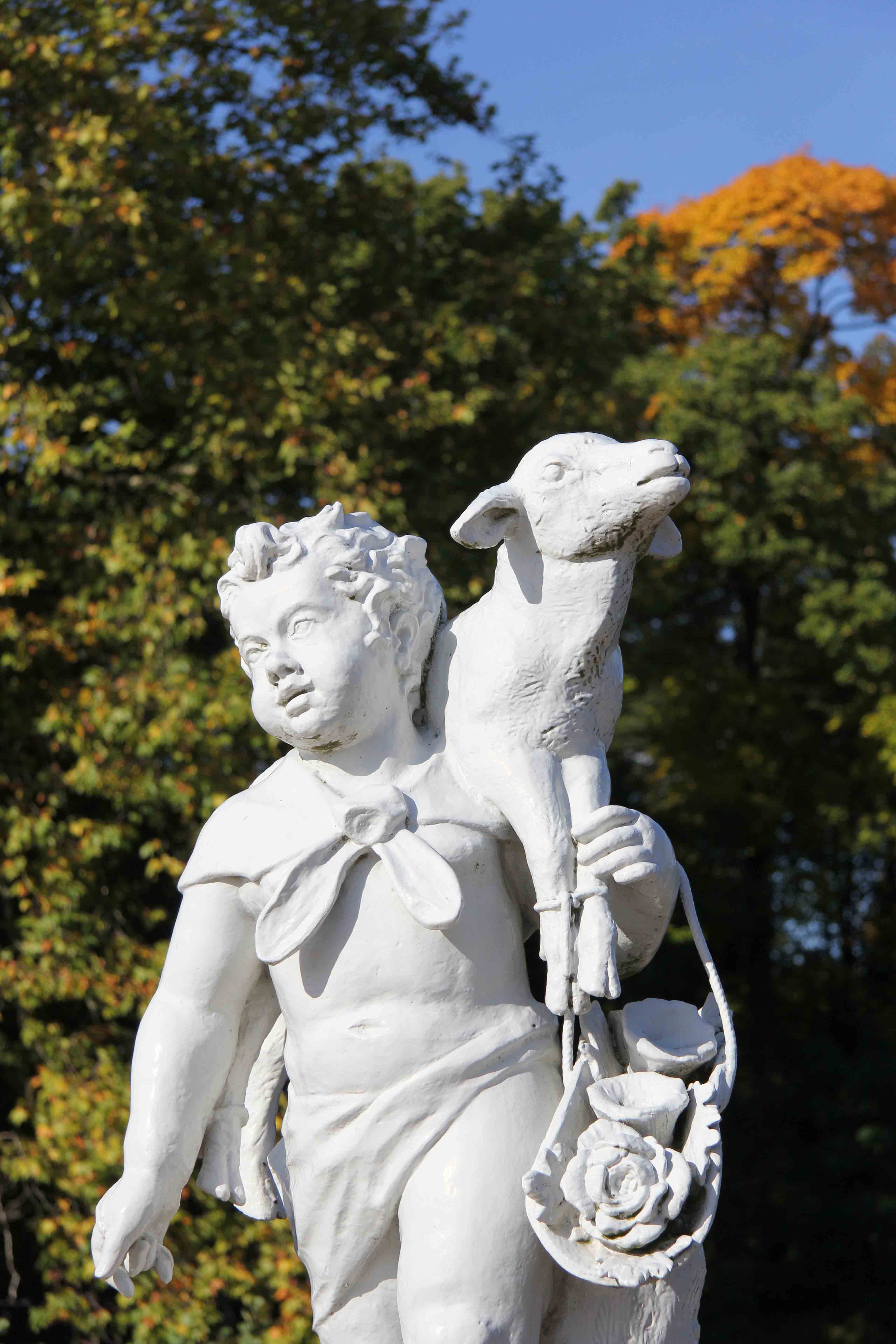 A statue of a child carrying a lamb in The Palace Gardens of Schloss Charlottenburg in Berlin