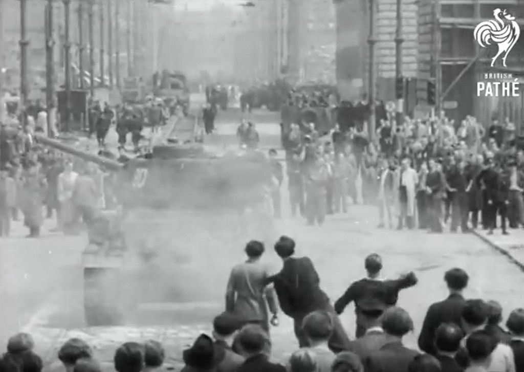 East Berliners throw rocks at a Soviet tank during the riots of the 17 June 1953 Uprising on the streets of East Berlin - Still from Berlin Riots British Pathé Newsreel