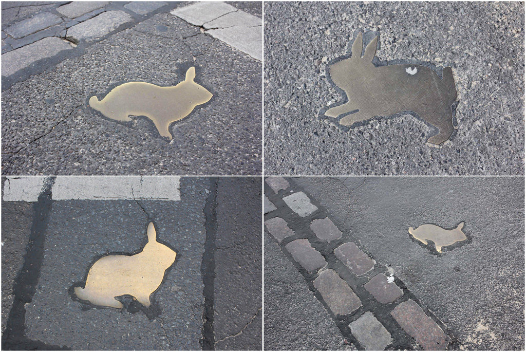 A collection of the brass rabbits on the road of the Kaninchenfeld (Rabbit Field), a memorial to the rabbits that lived on the Berlin Wall death strip by Karla Sachse at the site of a former border crossing point on the Chausseestrasse in Berlin