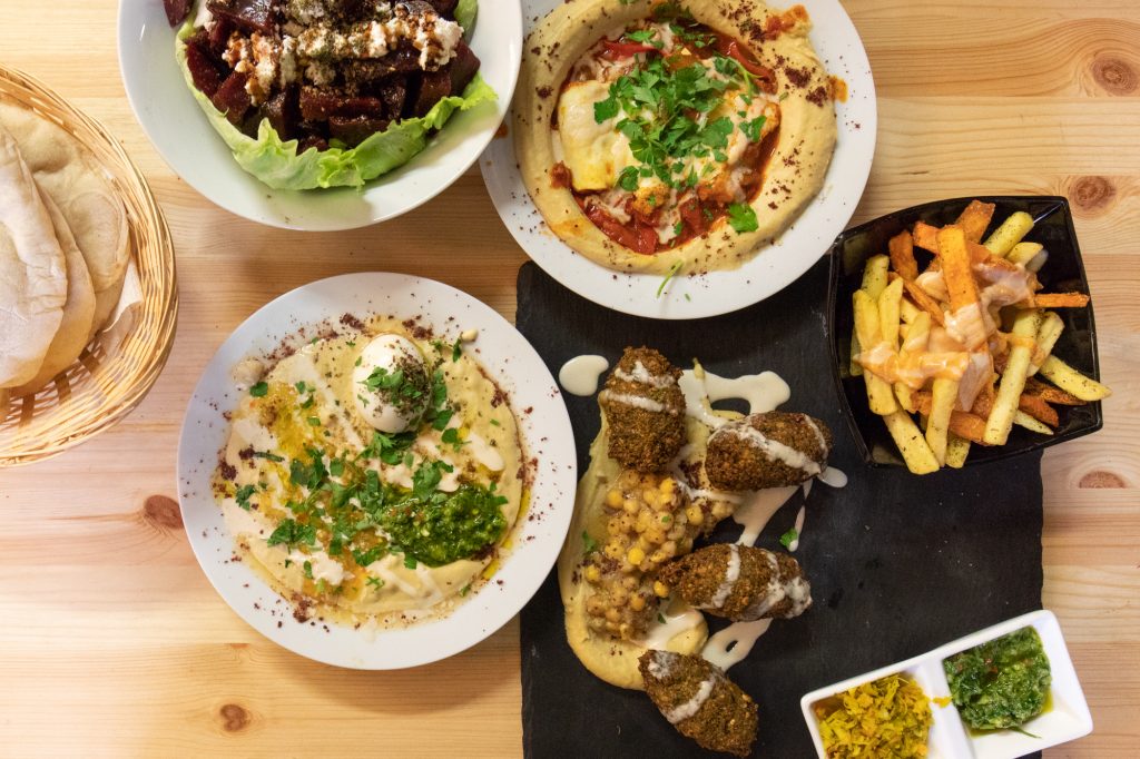 Ein Fest - Falafel Teller, Rote Beete Salat, Masabacha, Hummshuka und Brot - im Kanaan in Berlin, ein modernes nahöstliches Restaurant, das von einem Israeli und einem Palästinenser geführt wird