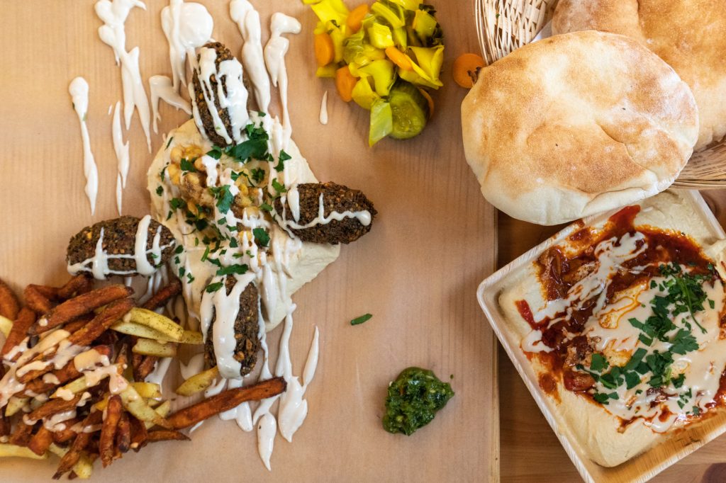 Falafel Teller, Hummshuka und Brot im Kanaan in Berlin, ein modernes nahöstliches Restaurant, das von einem Israeli und einem Palästinenser geführt wird