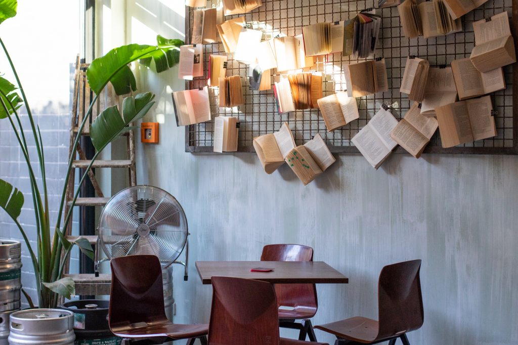 Tisch, Stühle und Bücher im Muted Horn, eine Craft Beer Bar in Berlin Neukölln